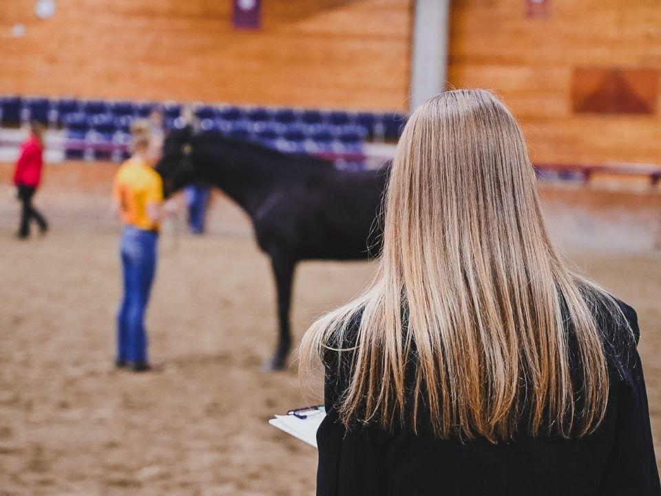 Student judging another student and her horse